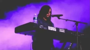 Piano lessons for singers Marbella – vocalist performing live while playing keyboard and singing on stage.